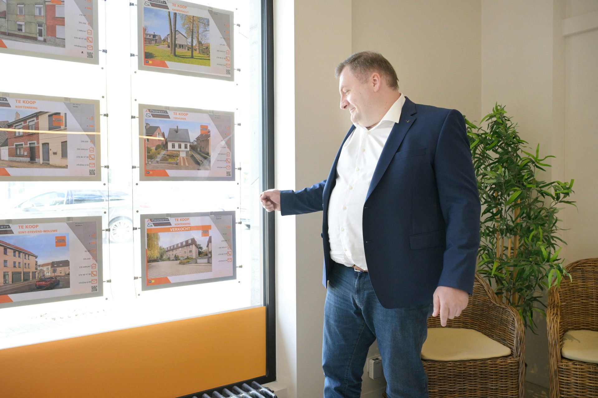 Man looking at real estate listings in a window display.